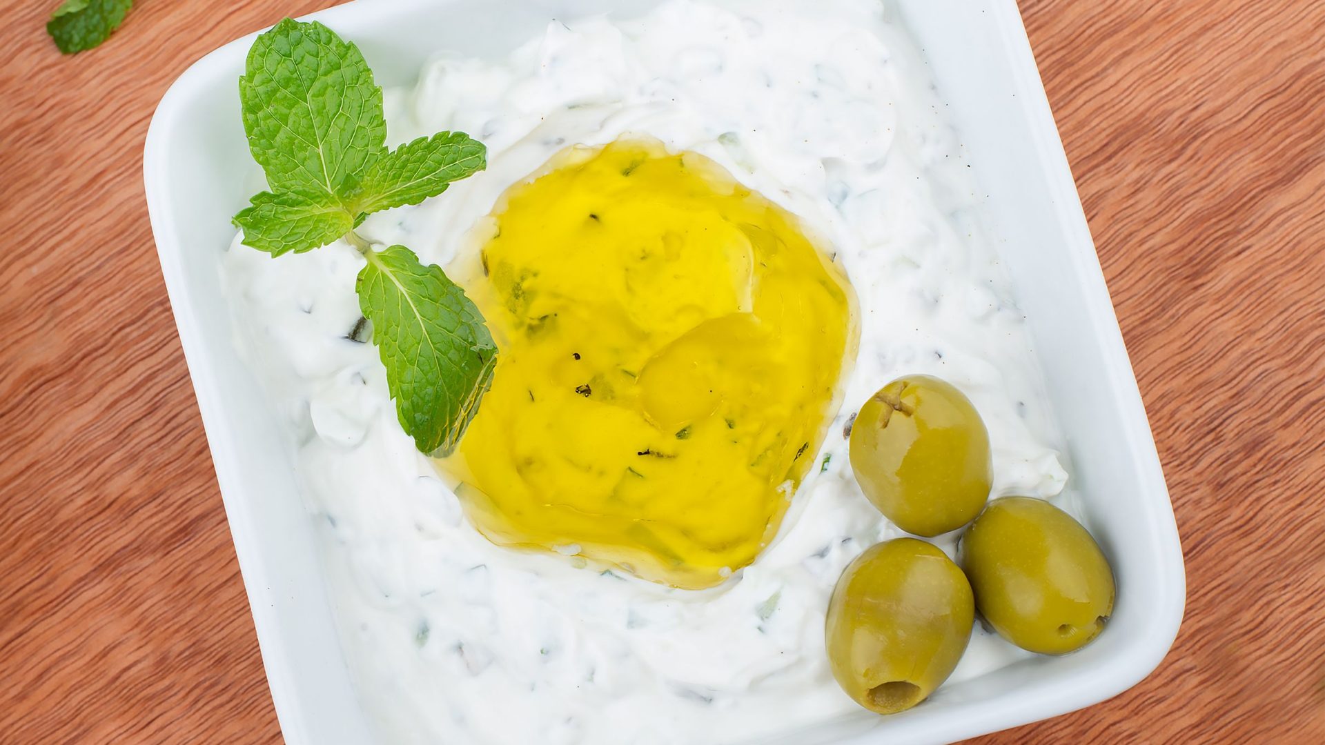 Frisches Tzatziki mit Minze, Olivenöl und grünen Oliven