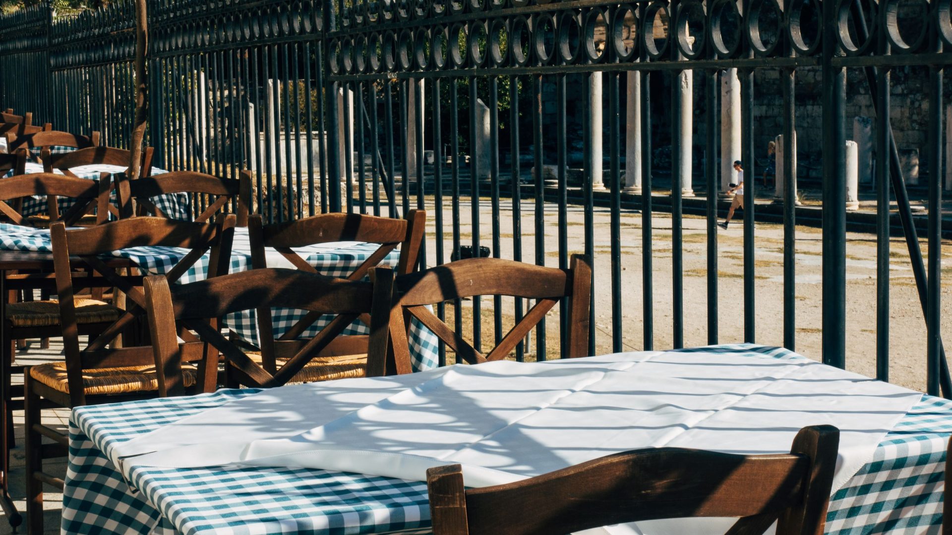 Gedeckte Tische im griechischen Taverna-Gastgarten