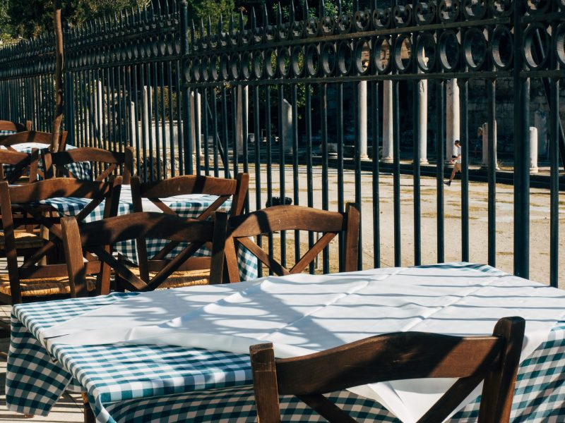 Gedeckte Tische im griechischen Taverna-Gastgarten