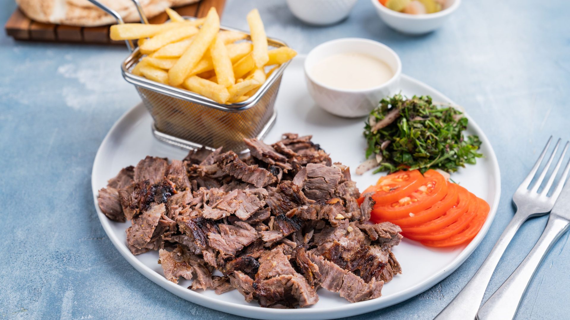Griechischer Fleischteller mit Pommes, Tzatziki und frischem Salat